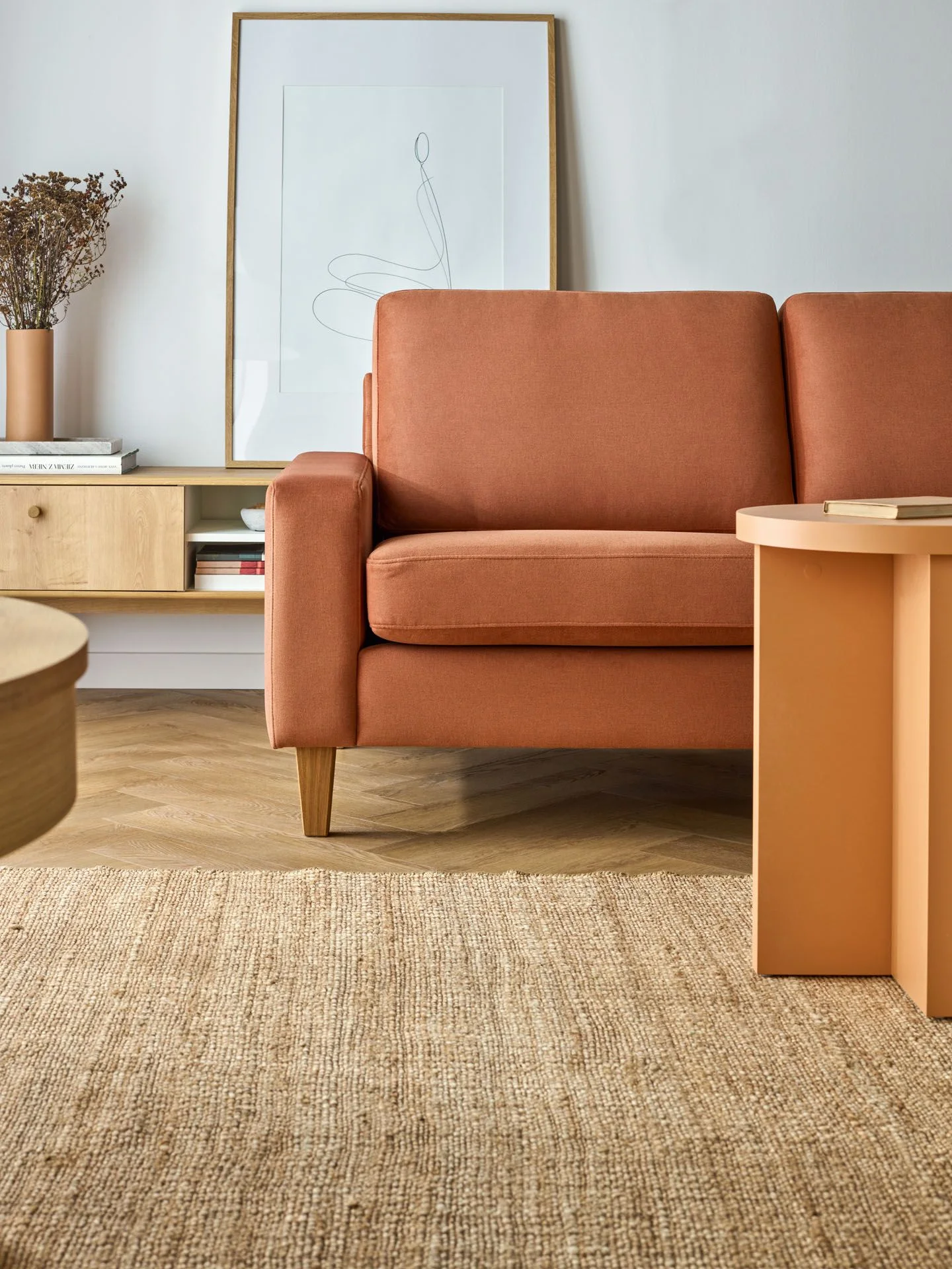 ruda sofa i pomarańczowy stolik kawowy